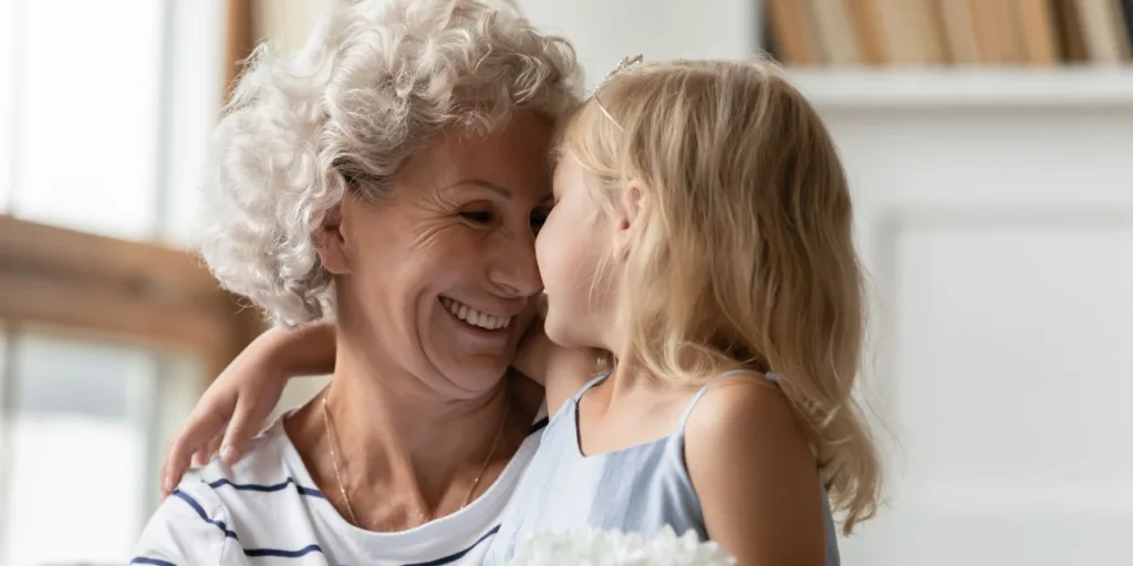 smiling grandma holding grand daughter