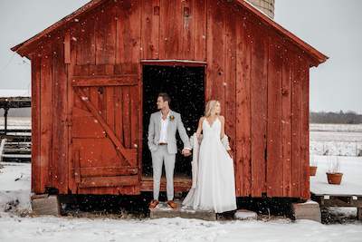 Bride and groom in front of a wedding barn