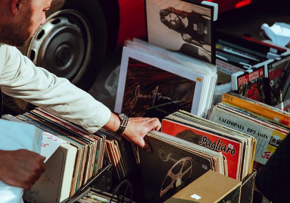 a person flipping through a collection of music records